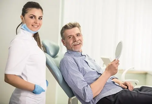 Dental hygienist and man in dental chair